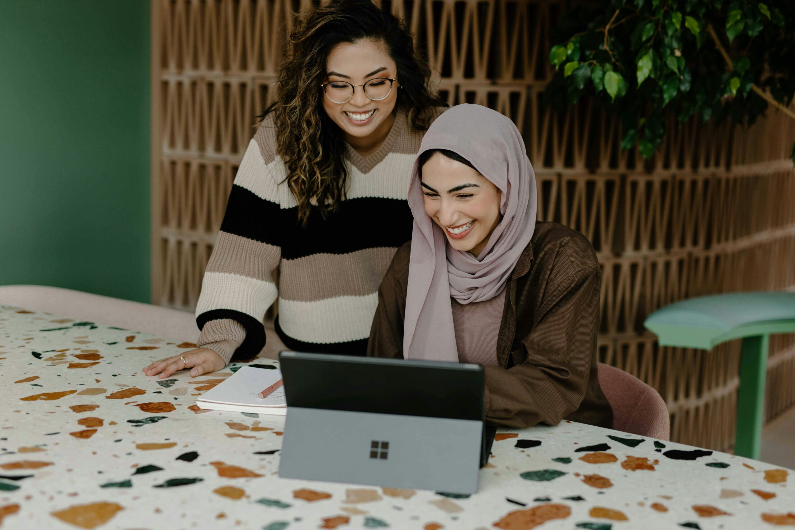 An image of two women creating a youtube channel on there computer.