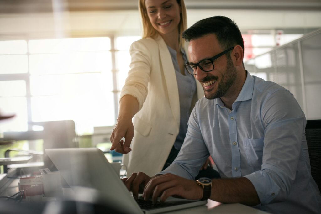 "A woman in a yellow suit coat instructs a man on how to start his own online business."