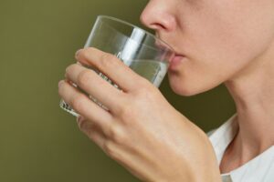 Woman drinking a glass of clear water.