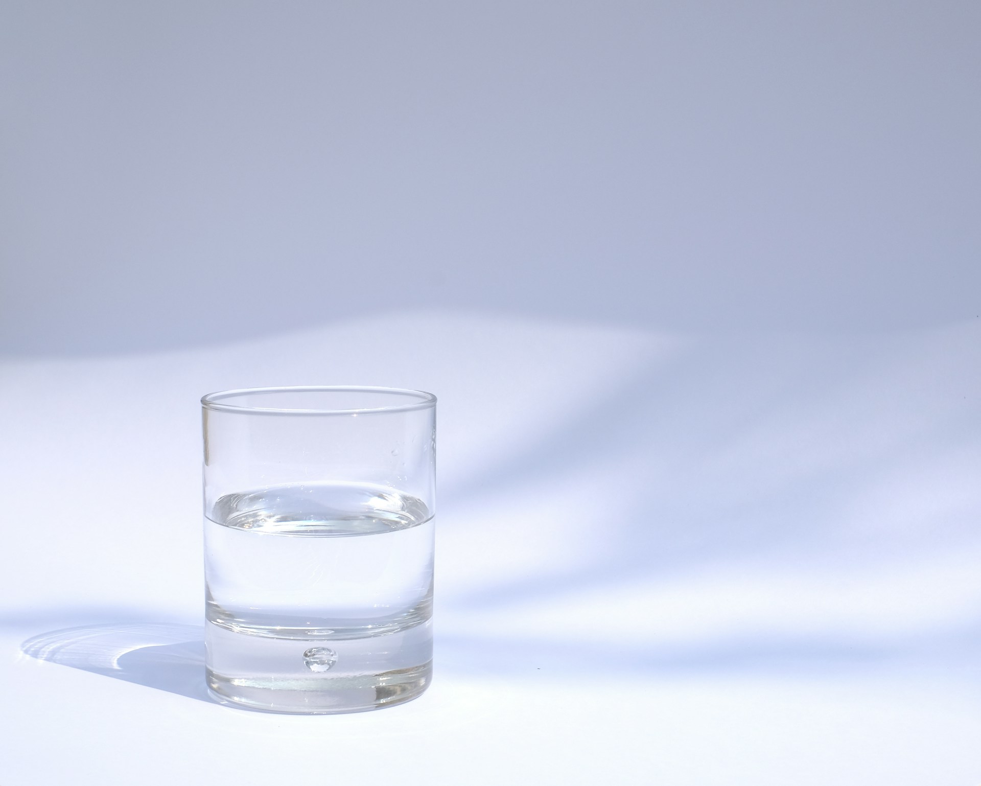 A clear glass of water on a white background, symbolizing the purity and high-quality standards of Enagic's certified water ionizers, delivering safe and effective hydration solutions.