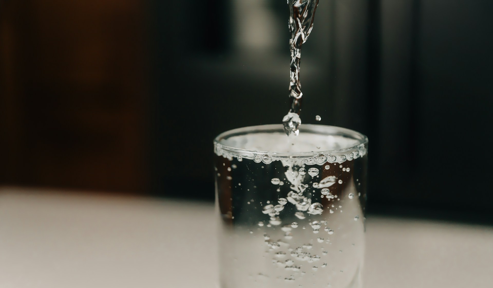 Crystal-clear water being poured into a glass, symbolizing health and wellness promoted by Kangen Water distributors Darren and Mike. The image reflects their journey in building a thriving business centered around hydration, antioxidant-rich water, and improved lifestyle choices.