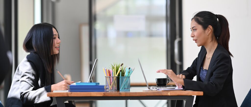 Two professionals engaged in a mentorship discussion, symbolizing the collaborative spirit and guidance essential in MLM success as outlined in 'The Power of Mentorship in MLM: Keys to Building a Winning Team.