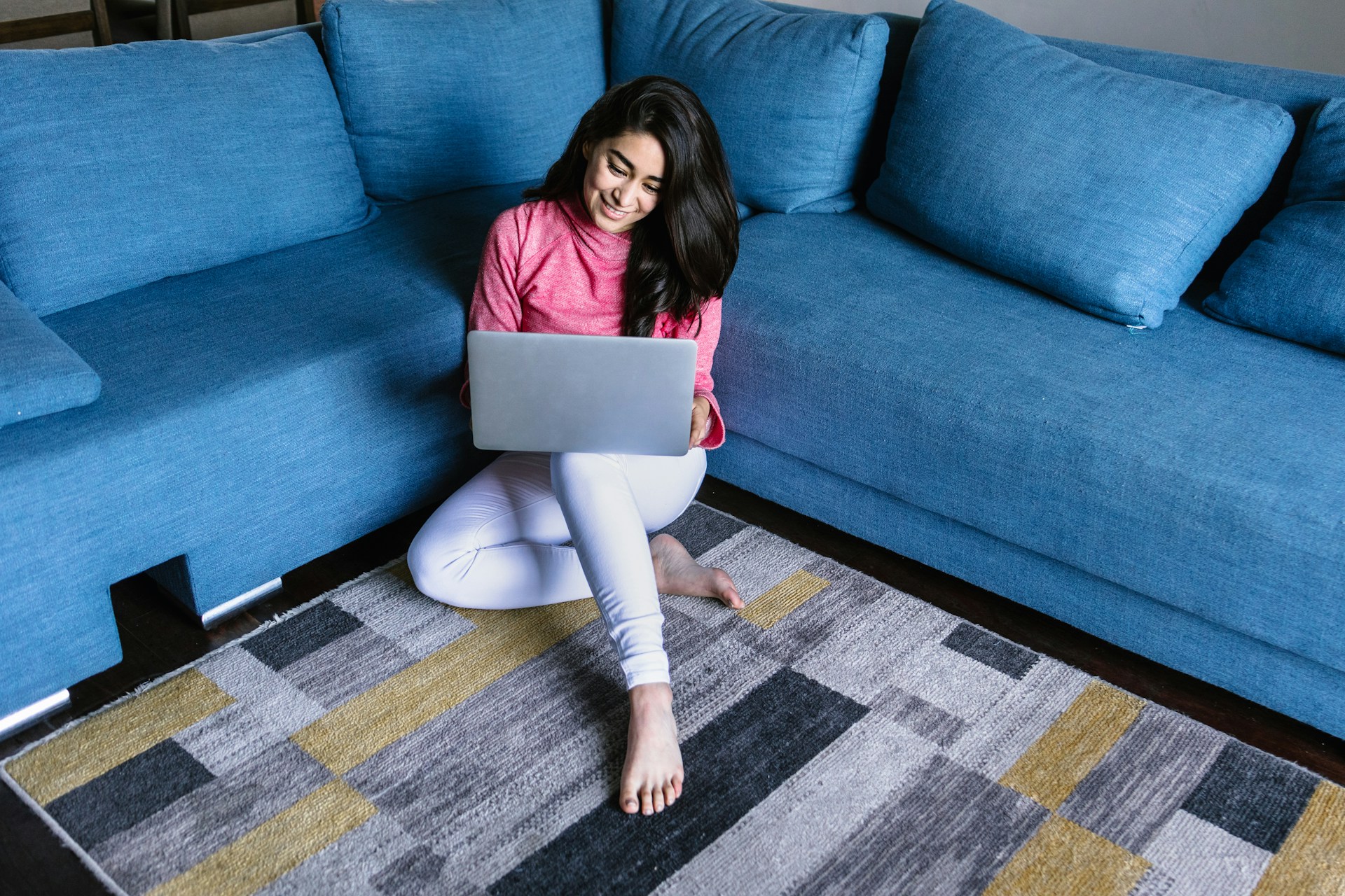 Smiling woman working on a laptop from home, representing the freedom and flexibility of the Darren and Mike Digital Business model.