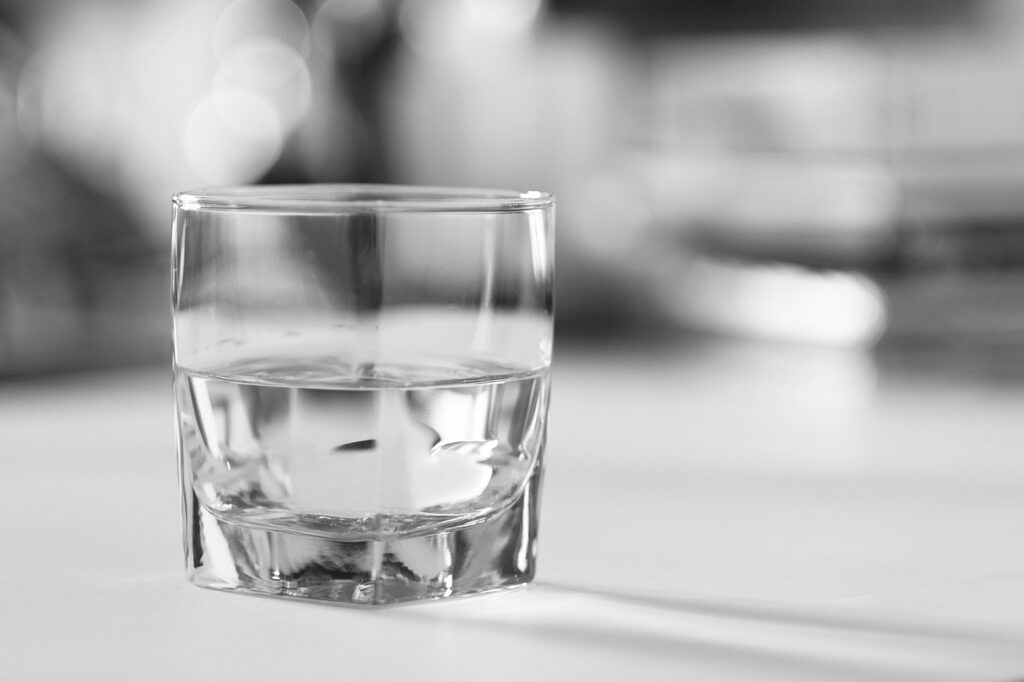 A minimalist glass of water on a bright surface, symbolizing purity, simplicity, and the clarity that Darren and Mike found through the Enagic MLM journey.