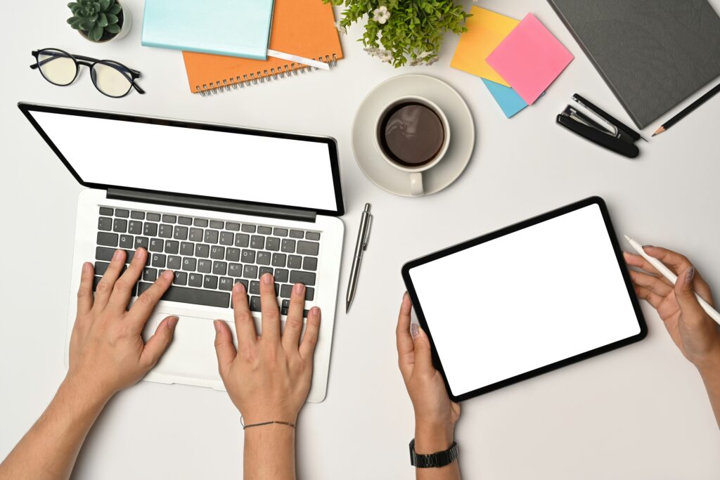 Modern workspace with laptop and tablet showing tools for starting a digital business and managing an online business plan