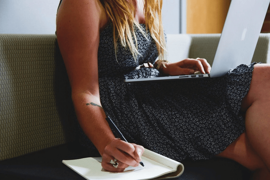  Beginner entrepreneur working on laptop and taking notes while starting a digital business.